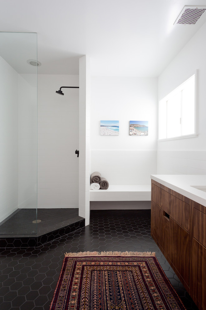 Modelo de cuarto de baño actual con armarios con paneles lisos, puertas de armario de madera oscura, ducha esquinera, paredes blancas, aseo y ducha y ducha abierta