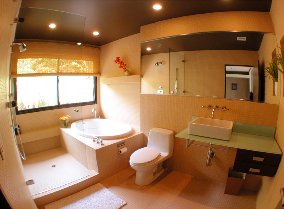Example of a large minimalist beige tile and mosaic tile ceramic tile bathroom design in Los Angeles with a vessel sink, flat-panel cabinets, dark wood cabinets, limestone countertops, a one-piece toilet and beige walls