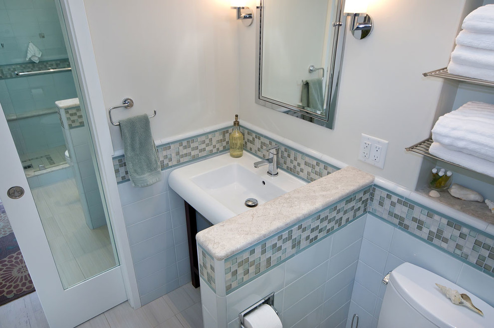 Bild på ett vintage badrum med dusch, med ett konsol handfat, öppna hyllor, skåp i mörkt trä, en toalettstol med separat cisternkåpa och blå kakel