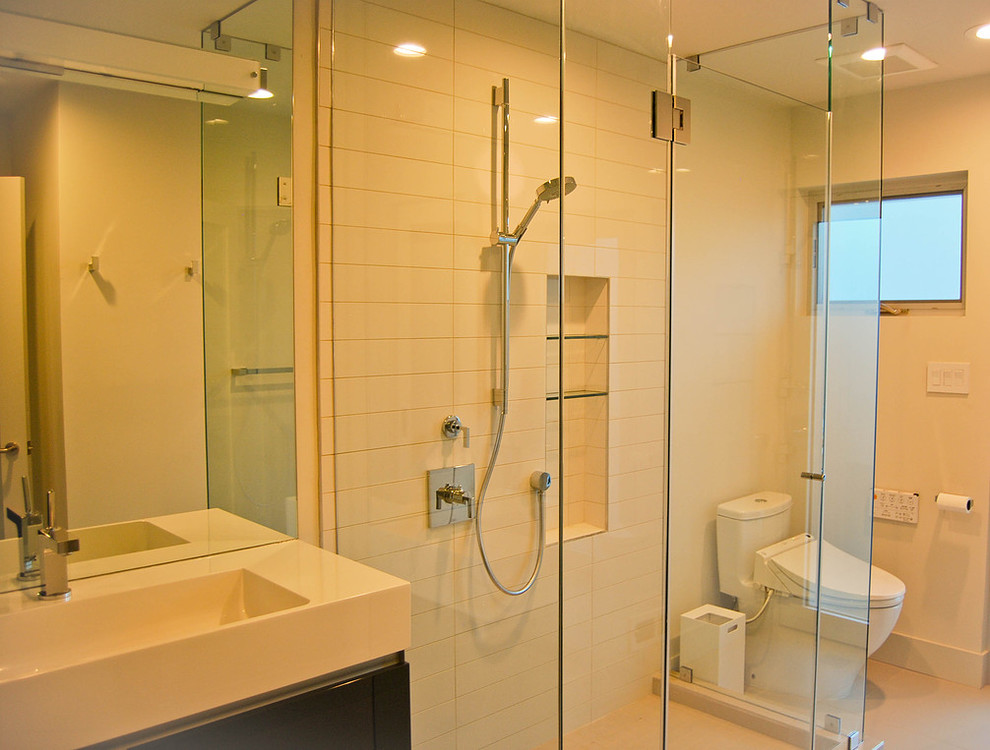 На фото: главная ванная комната среднего размера в стиле модернизм с плоскими фасадами, темными деревянными фасадами, душем в нише, унитазом-моноблоком, белыми стенами и раковиной с несколькими смесителями