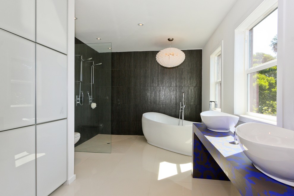 Свежая идея для дизайна: ванная комната в современном стиле с настольной раковиной, отдельно стоящей ванной, открытым душем, черной плиткой и открытым душем - отличное фото интерьера