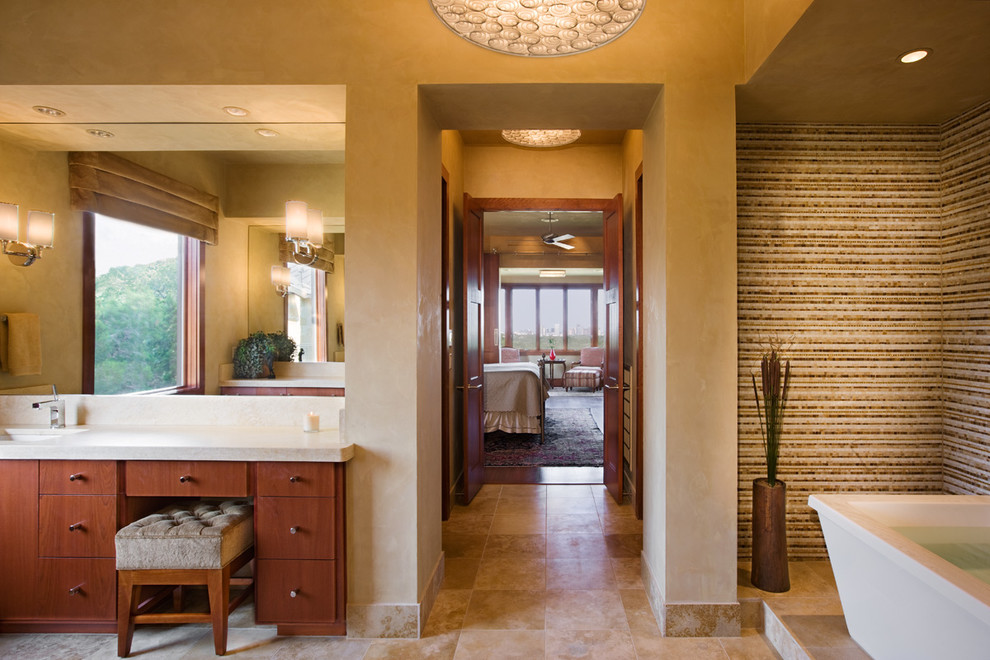 Modelo de cuarto de baño principal actual con lavabo integrado, bañera exenta y paredes beige