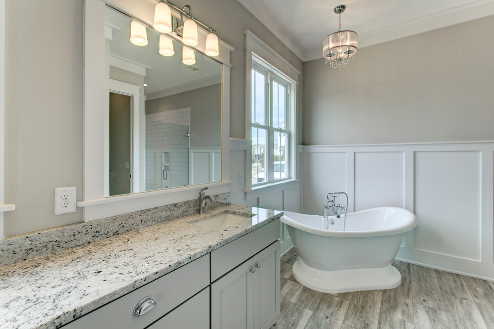 Example of a mid-sized farmhouse master white tile and ceramic tile ceramic tile and gray floor bathroom design in Raleigh with shaker cabinets, gray cabinets, a two-piece toilet, gray walls, an undermount sink, granite countertops and a hinged shower door