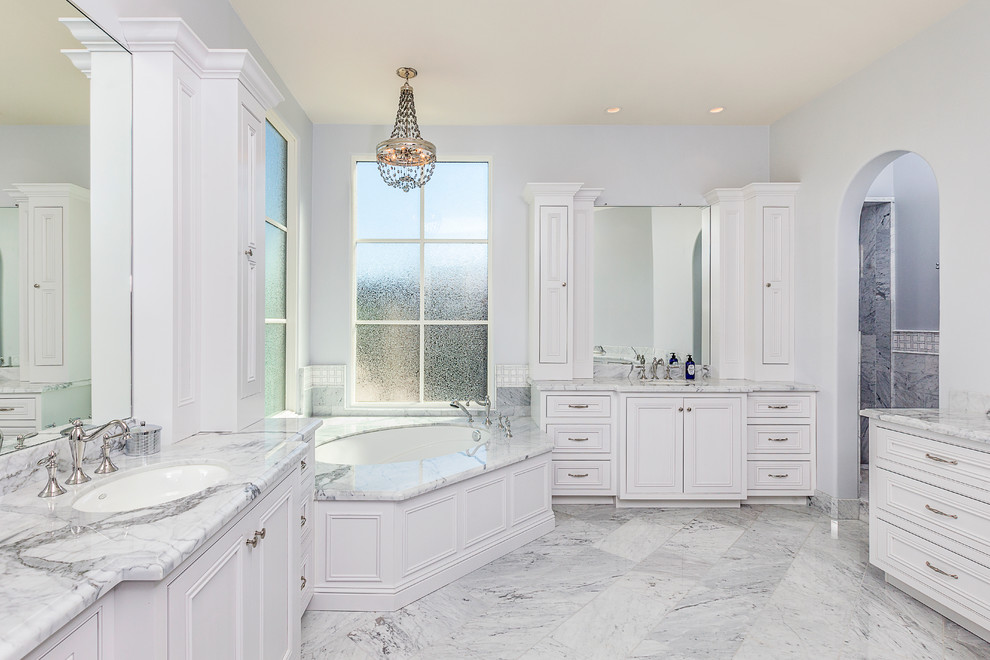 Corner bathtub - mid-sized transitional master white tile and stone tile corner bathtub idea in Phoenix with beaded inset cabinets, white cabinets, marble countertops, gray walls and an undermount sink