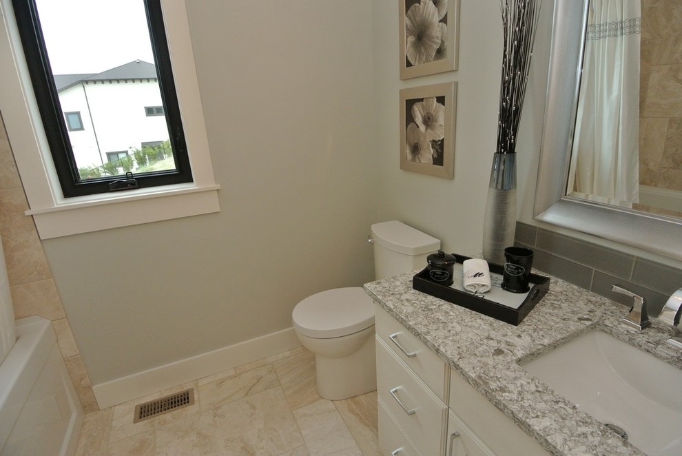 Example of a mid-sized transitional gray tile and ceramic tile ceramic tile and beige floor bathroom design in Other with flat-panel cabinets, white cabinets, a two-piece toilet, gray walls, a wall-mount sink, quartzite countertops and gray countertops
