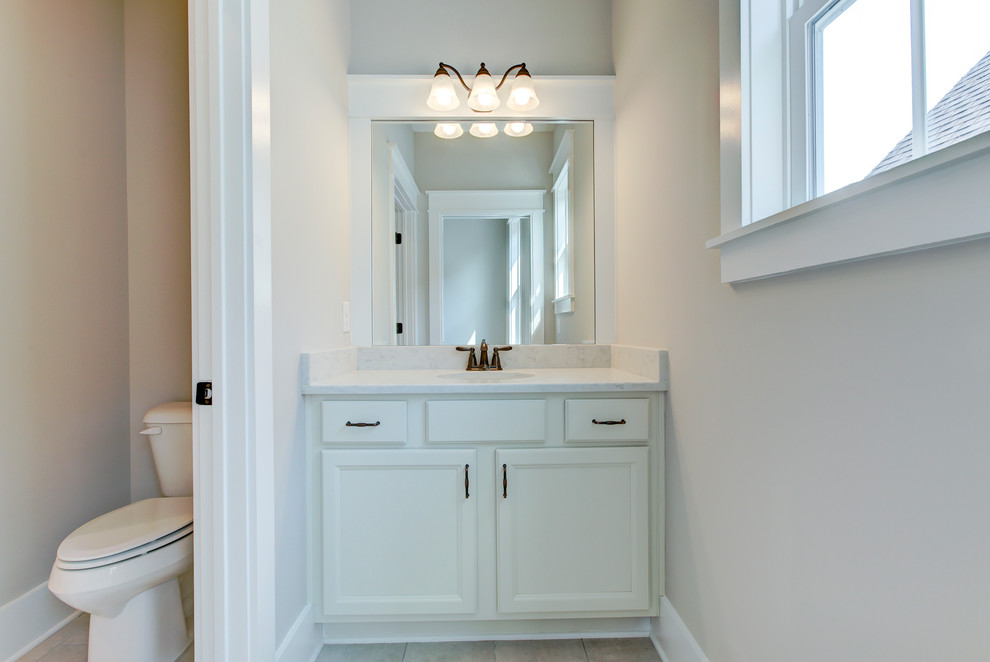 Design ideas for a small country family bathroom in Raleigh with shaker cabinets, white cabinets, an alcove bath, a shower/bath combination, a two-piece toilet, grey walls, ceramic flooring, a submerged sink, engineered stone worktops, grey floors and a shower curtain.