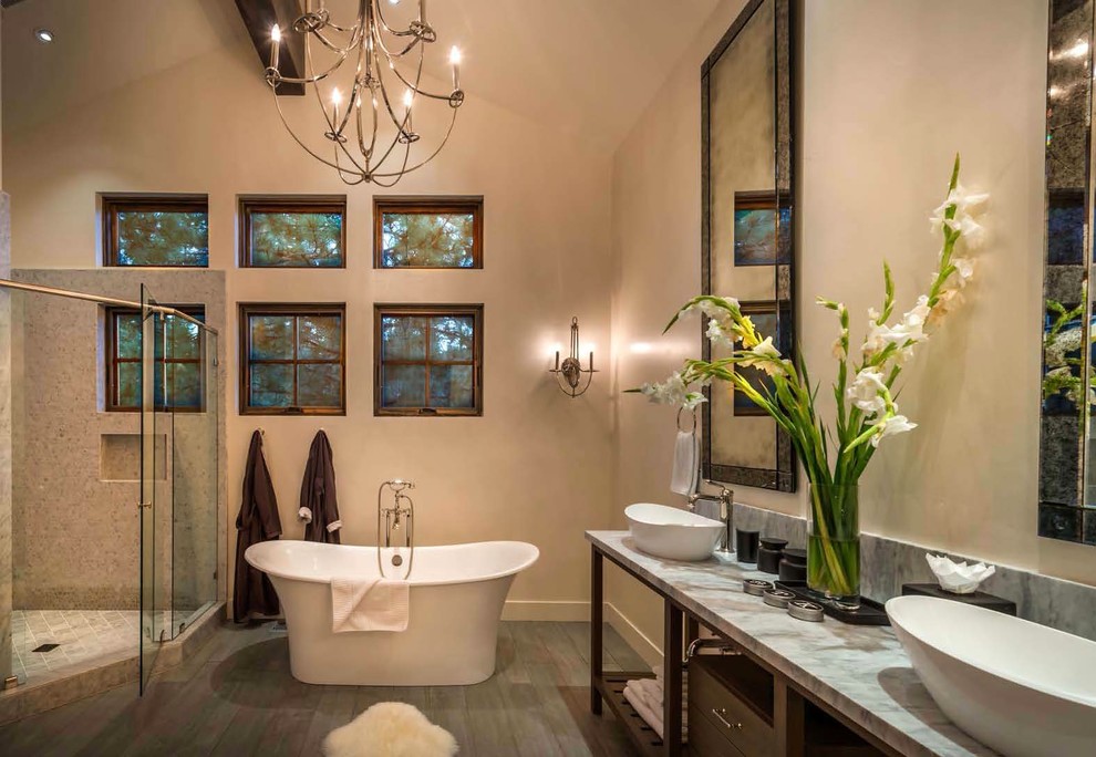 Rustikales Badezimmer mit Aufsatzwaschbecken, dunklen Holzschränken, freistehender Badewanne, beiger Wandfarbe und grauer Waschtischplatte in Sacramento