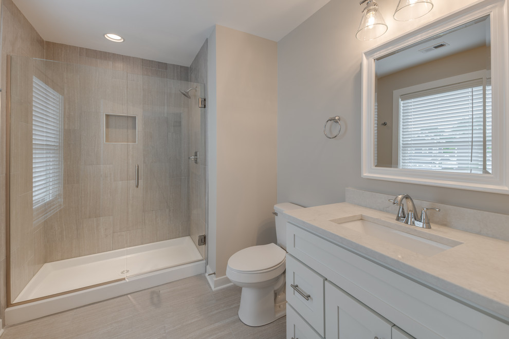 Exempel på ett mellanstort lantligt vit vitt en-suite badrum, med skåp i shakerstil, vita skåp, en dusch i en alkov, en toalettstol med separat cisternkåpa, grå väggar, klinkergolv i porslin, ett undermonterad handfat, bänkskiva i kvartsit, grått golv och dusch med gångjärnsdörr