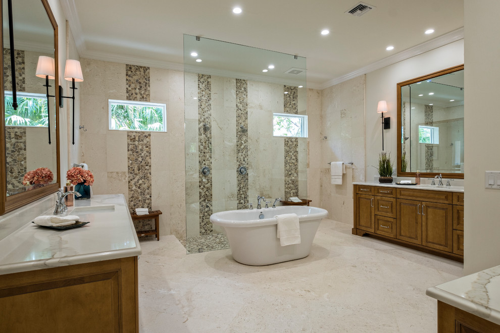 Inspiration for a large contemporary master beige tile, brown tile and pebble tile porcelain tile and beige floor bathroom remodel in Miami with raised-panel cabinets, medium tone wood cabinets, beige walls, an undermount sink and marble countertops