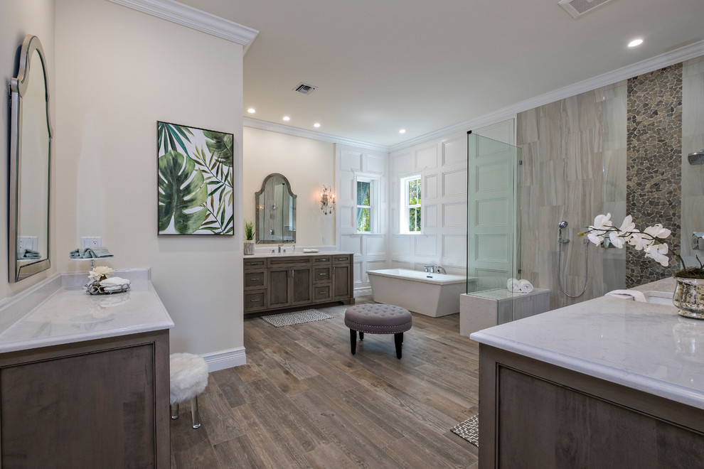 Inspiration for a large classic ensuite bathroom in Miami with recessed-panel cabinets, medium wood cabinets, a freestanding bath, a built-in shower, beige tiles, porcelain tiles, beige walls, medium hardwood flooring, a submerged sink, quartz worktops and an open shower.