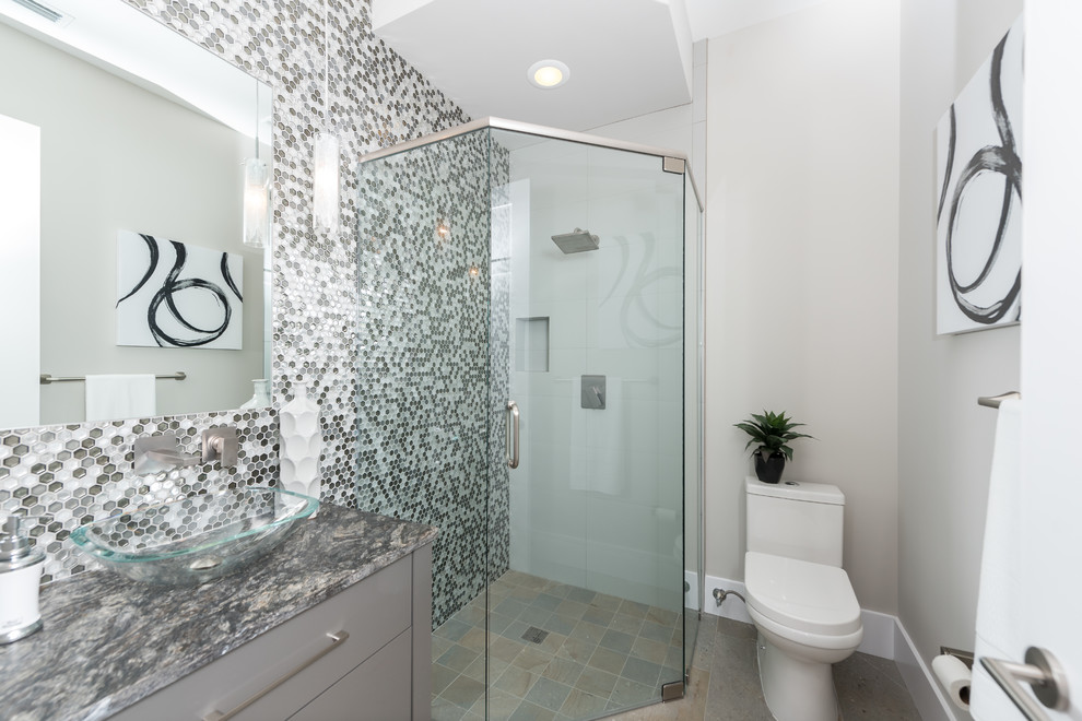 Design ideas for a contemporary shower room bathroom in Orlando with flat-panel cabinets, grey cabinets, a built-in shower, a two-piece toilet, grey tiles, white tiles, mosaic tiles, grey walls, a vessel sink, grey floors, a hinged door and grey worktops.