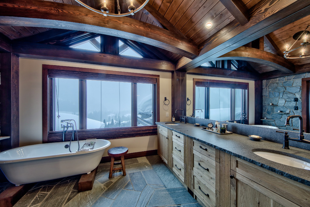 This is an example of a large rustic ensuite bathroom in Vancouver with flat-panel cabinets, light wood cabinets, a freestanding bath, a walk-in shower, a one-piece toilet, beige walls, concrete flooring, a built-in sink and concrete worktops.