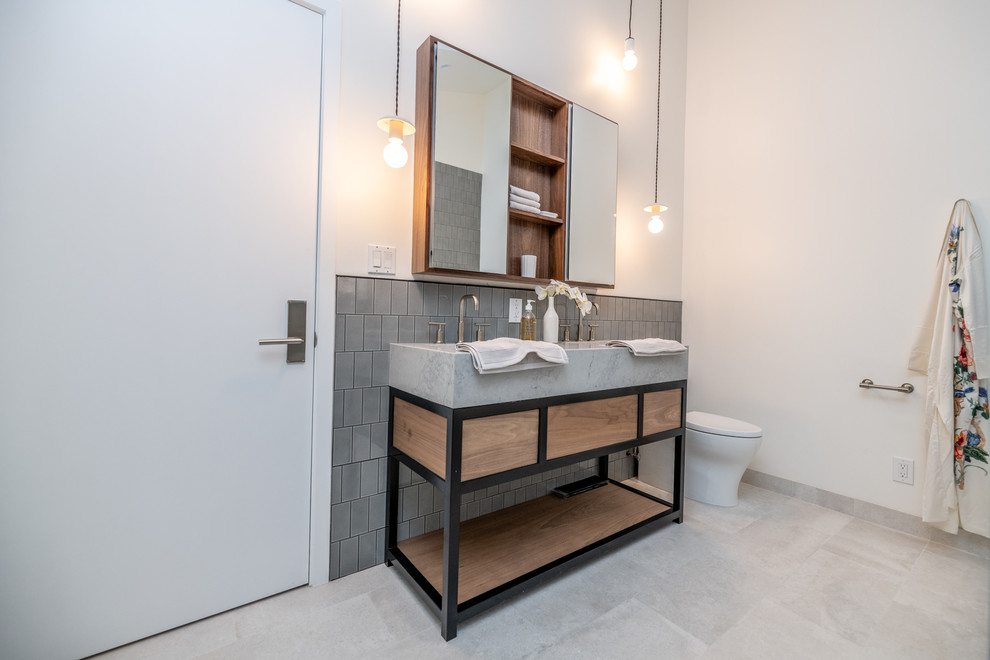 Mid-sized 1960s master gray tile and ceramic tile porcelain tile and gray floor bathroom photo in Los Angeles with open cabinets, dark wood cabinets, a one-piece toilet, white walls, an undermount sink, quartz countertops, a hinged shower door and gray countertops