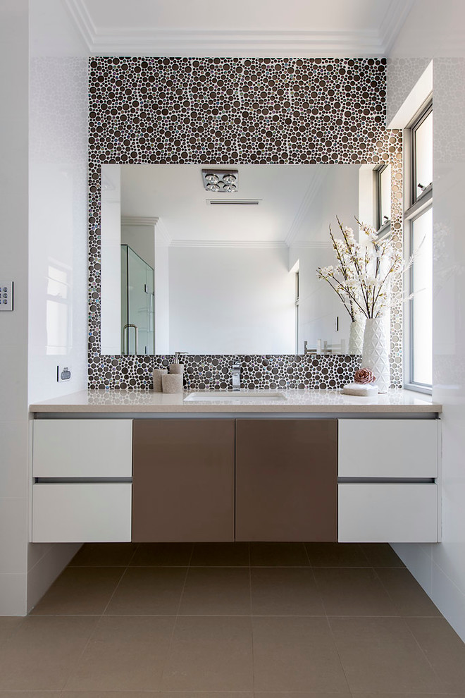 Imagen de cuarto de baño contemporáneo con lavabo bajoencimera, armarios con paneles lisos y baldosas y/o azulejos beige