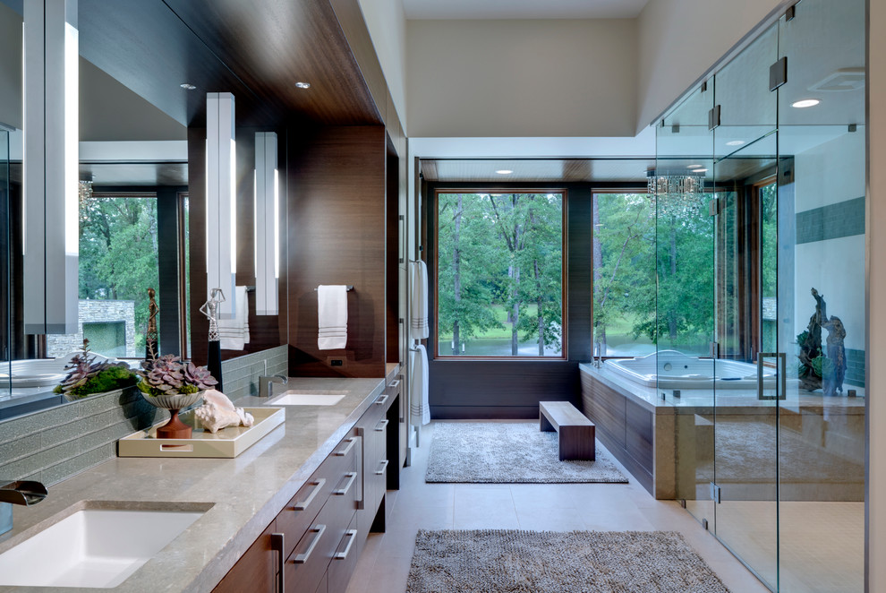 Diseño de cuarto de baño contemporáneo con lavabo bajoencimera, armarios con paneles lisos, puertas de armario de madera oscura, bañera encastrada, ducha a ras de suelo y baldosas y/o azulejos grises