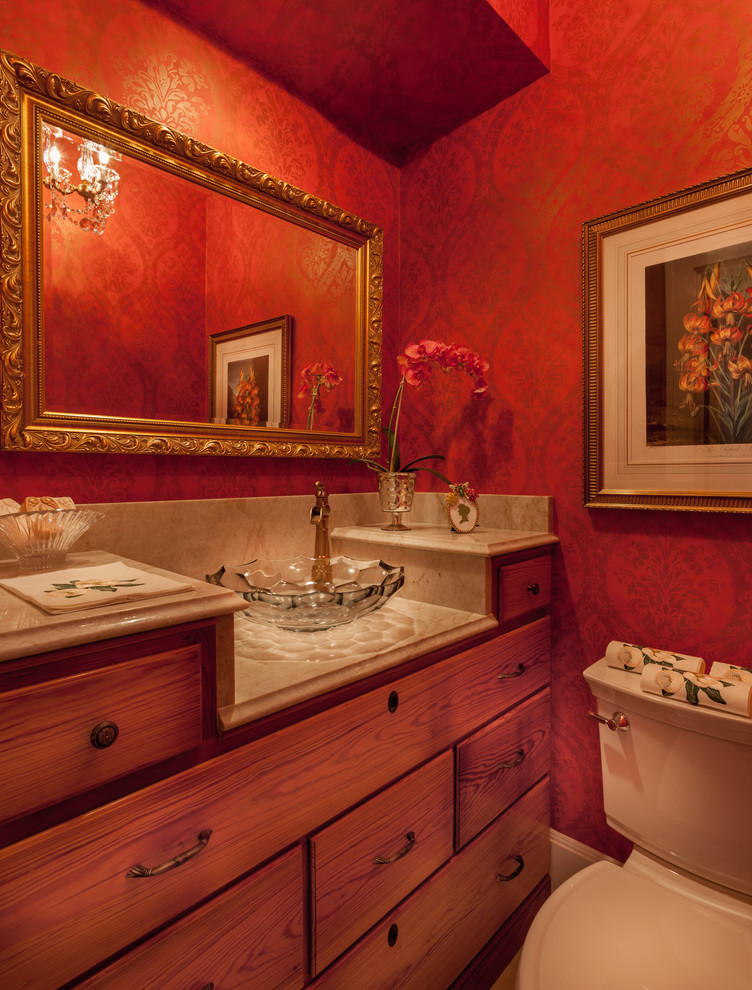 Immagine di una stanza da bagno con lavabo a bacinella, ante in legno scuro, top in quarzite e pareti rosse
