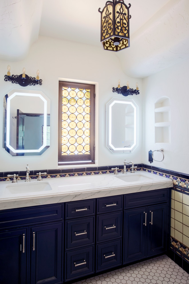 На фото: главная ванная комната среднего размера в средиземноморском стиле с синими фасадами, полом из керамогранита, врезной раковиной, мраморной столешницей, белой столешницей, тумбой под две раковины и встроенной тумбой с