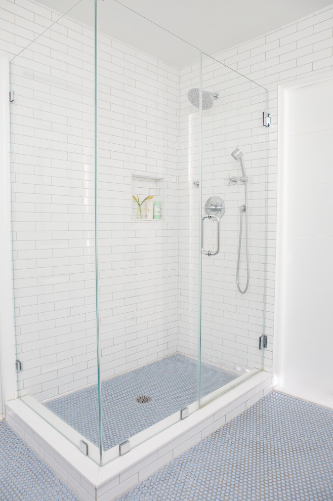 This is an example of a modern ensuite bathroom in New York with beaded cabinets, white cabinets, a built-in bath, a walk-in shower, a two-piece toilet, white tiles, metro tiles, white walls, a built-in sink, marble worktops, blue floors, a hinged door, white worktops, double sinks and a freestanding vanity unit.