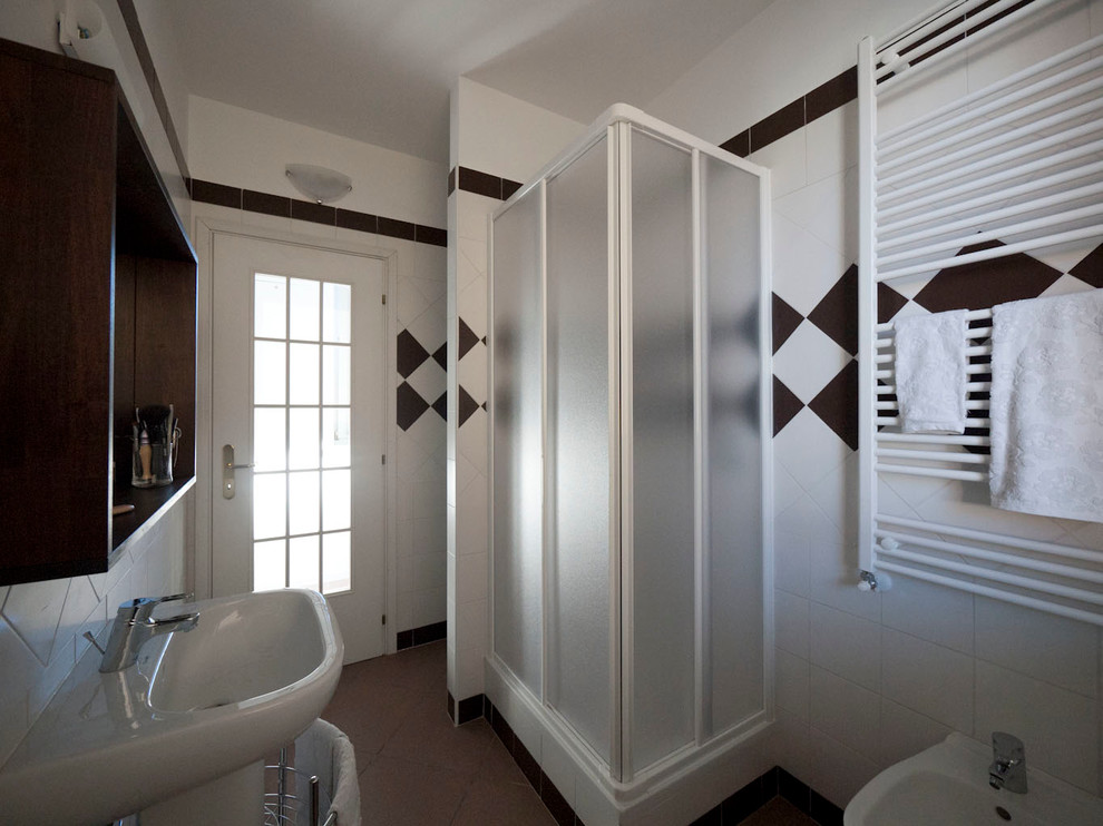 Idéer för ett litet modernt en-suite badrum, med ett piedestal handfat, en hörndusch, en toalettstol med separat cisternkåpa, vit kakel, keramikplattor, vita väggar och klinkergolv i keramik