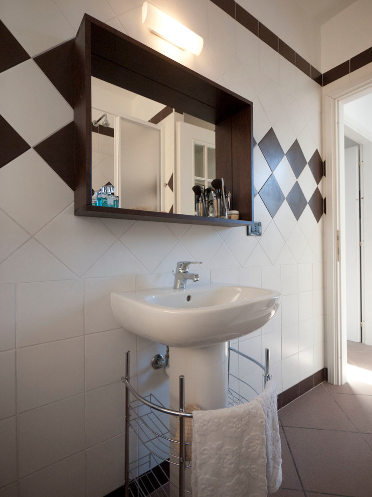 Foto på ett litet funkis en-suite badrum, med ett piedestal handfat, en hörndusch, en toalettstol med separat cisternkåpa, vit kakel, keramikplattor, vita väggar och klinkergolv i keramik