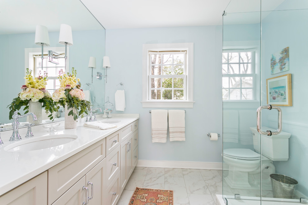 На фото: ванная комната в стиле неоклассика (современная классика) с бежевыми фасадами, синими стенами, полом из керамической плитки, врезной раковиной, столешницей из кварцита, белым полом, белой столешницей, фасадами с утопленной филенкой, угловым душем и душем с распашными дверями