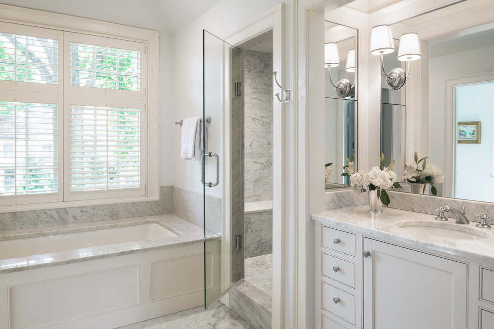 Photo of a classic bathroom in DC Metro with beaded cabinets, white cabinets, a submerged bath, white tiles, grey walls and a submerged sink.