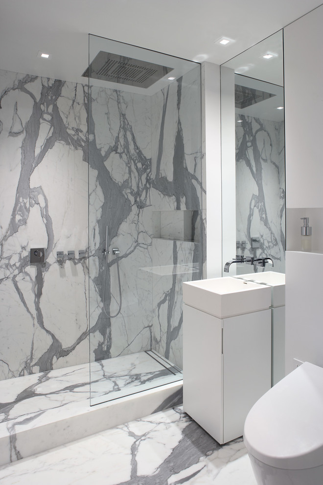 This is an example of a contemporary bathroom in New York with an alcove shower, flat-panel cabinets, white cabinets, white tiles and a pedestal sink.