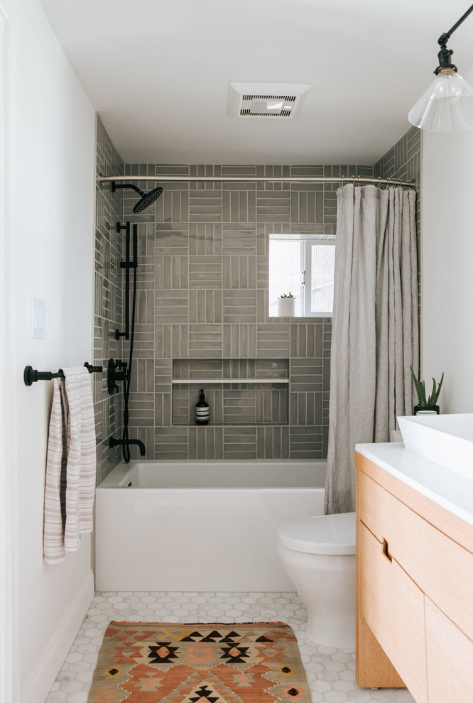 Inspiration for a small contemporary family bathroom in Other with flat-panel cabinets, light wood cabinets, an alcove bath, a shower/bath combination, a two-piece toilet, grey tiles, porcelain tiles, white walls, marble flooring, a vessel sink, quartz worktops, grey floors, a shower curtain and white worktops.
