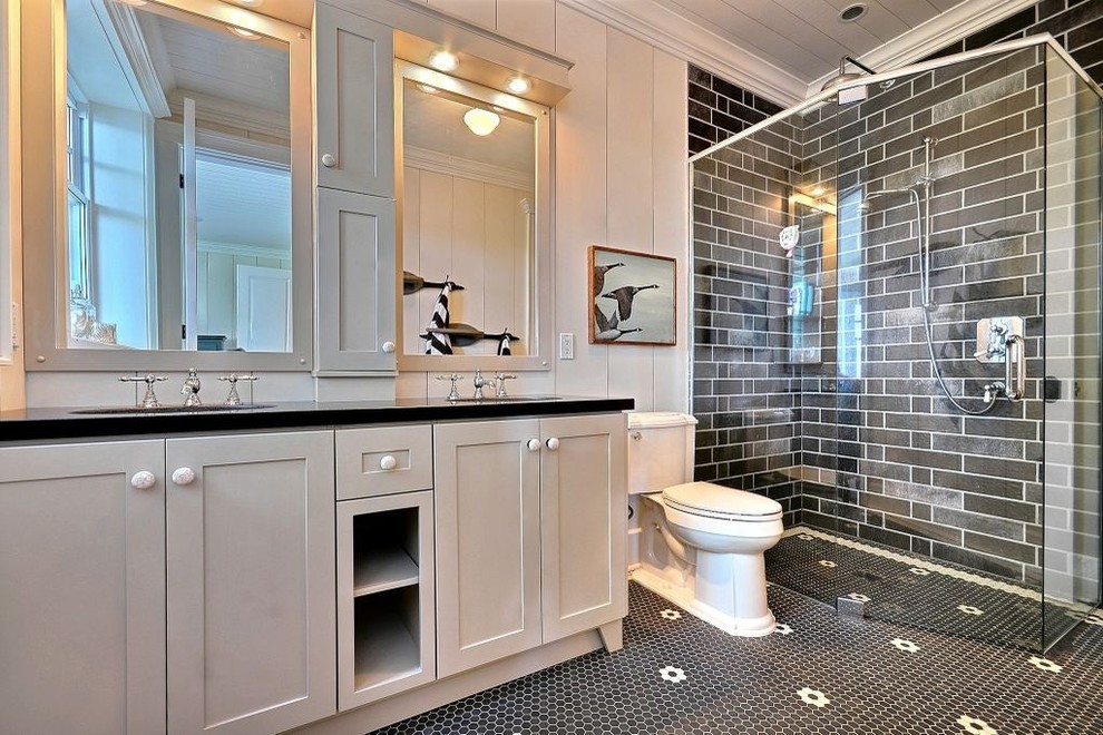 This is an example of a traditional bathroom in Toronto with shaker cabinets, grey cabinets, a two-piece toilet and black tiles.