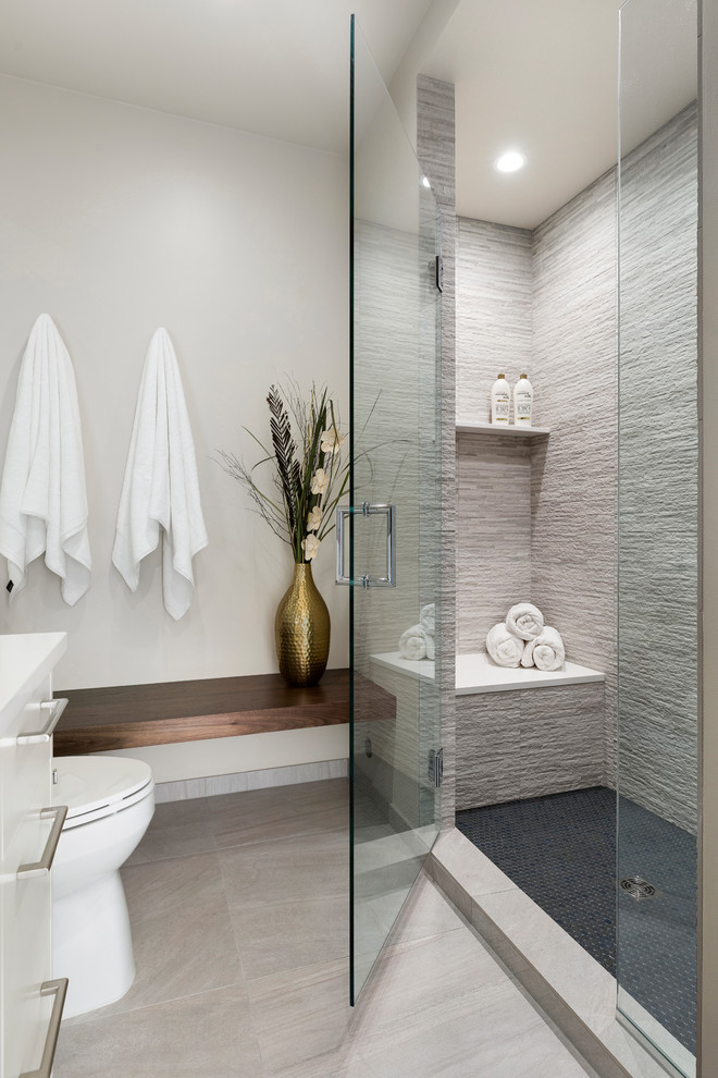 Example of a mid-sized minimalist master gray tile and stone tile porcelain tile and beige floor alcove shower design in Minneapolis with flat-panel cabinets, white cabinets, a two-piece toilet, white walls, an undermount sink, quartz countertops and a hinged shower door