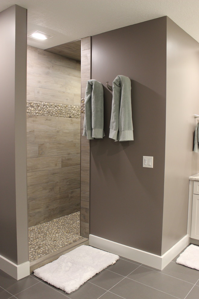 Example of a large transitional master gray tile and pebble tile ceramic tile and gray floor bathroom design in Other with flat-panel cabinets, white cabinets, gray walls, a vessel sink and quartz countertops