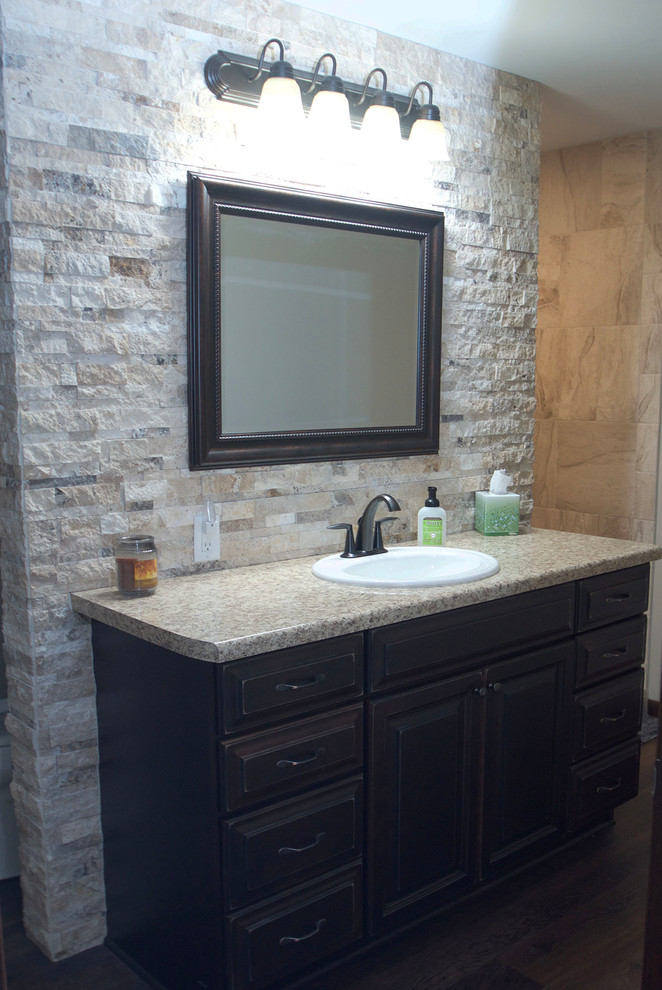 This is an example of a rustic ensuite bathroom in Other with raised-panel cabinets, distressed cabinets, an alcove shower, beige tiles, stone tiles, medium hardwood flooring and brown floors.