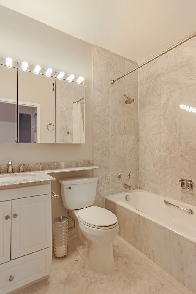 Idées déco pour une petite salle de bain contemporaine avec un combiné douche/baignoire, un carrelage gris et un mur gris.