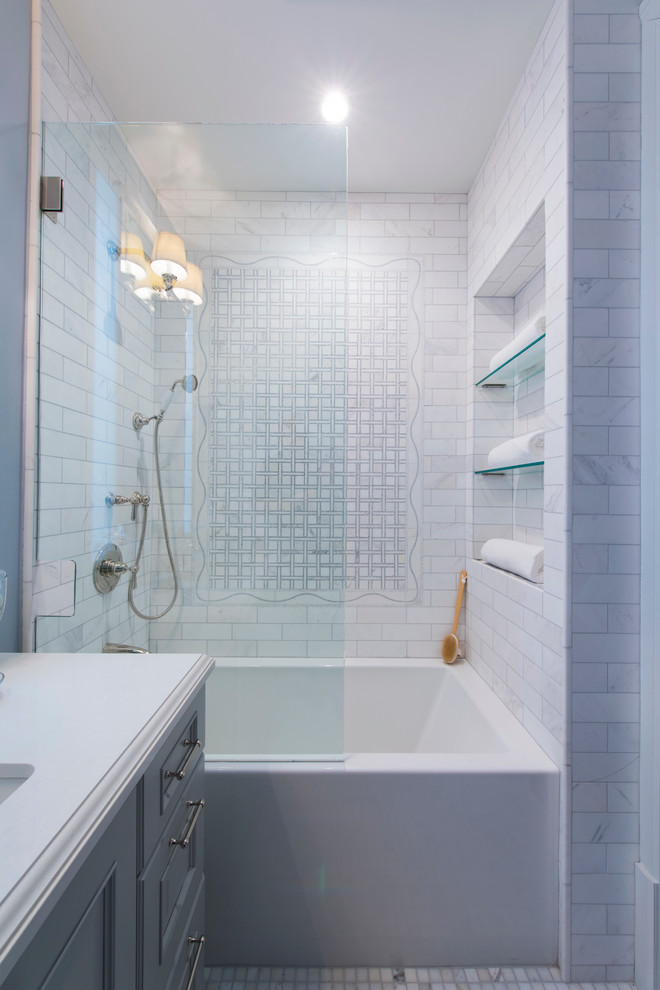 Aménagement d'une salle de bain classique avec un lavabo encastré, un placard avec porte à panneau surélevé, des portes de placard grises, un carrelage gris et un mur bleu.