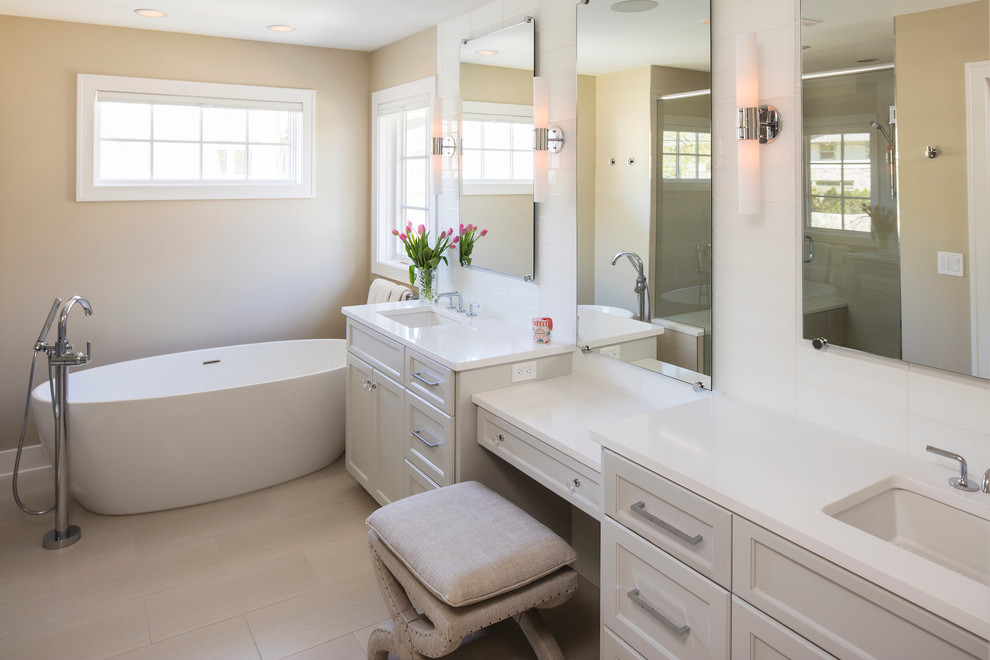 Inspiration for a medium sized classic ensuite bathroom in Minneapolis with recessed-panel cabinets, grey cabinets, a freestanding bath, an alcove shower, white tiles, pebble tiles, beige walls, light hardwood flooring, a submerged sink and solid surface worktops.