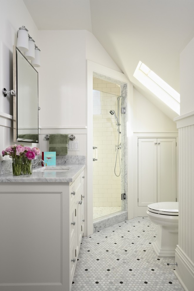 На фото: ванная комната в классическом стиле с белыми фасадами, угловым душем, белыми стенами, полом из мозаичной плитки, душевой кабиной, врезной раковиной, белым полом, душем с распашными дверями и серой столешницей с