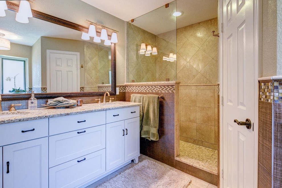 Mid-sized elegant master multicolored tile and glass tile porcelain tile doorless shower photo in Dallas with an undermount sink, furniture-like cabinets, beige cabinets, granite countertops, a two-piece toilet and multicolored walls