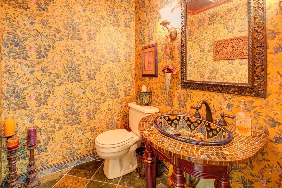 Esempio di una piccola stanza da bagno bohémian con lavabo da incasso, ante con finitura invecchiata, top piastrellato, WC a due pezzi, piastrelle di vetro, pareti multicolore e pavimento in ardesia