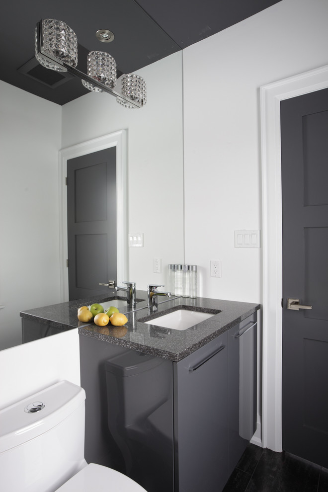 Design ideas for a small modern shower room bathroom in Toronto with grey cabinets, an alcove bath, a shower/bath combination, a two-piece toilet, black tiles, grey tiles, grey walls, porcelain flooring, a submerged sink, granite worktops, flat-panel cabinets and grey worktops.