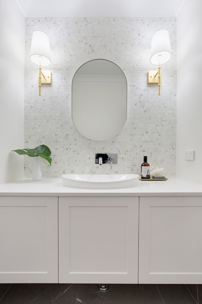 На фото: большая главная ванная комната в современном стиле с плоскими фасадами, белыми фасадами, разноцветной плиткой, мраморной плиткой, монолитной раковиной и столешницей из искусственного кварца с