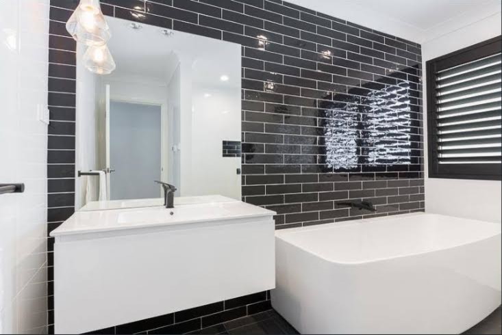 Modernes Badezimmer mit flächenbündigen Schrankfronten, weißen Schränken, freistehender Badewanne, schwarzen Fliesen, Metrofliesen, weißer Wandfarbe, Keramikboden, Einbauwaschbecken und schwarzem Boden in Sydney