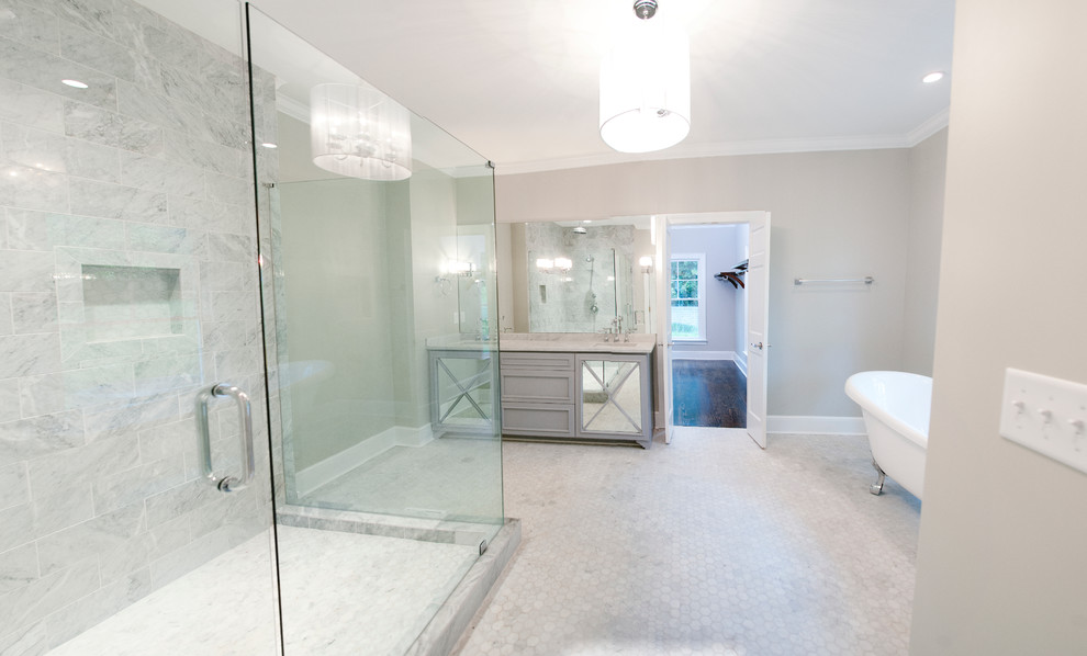 Aménagement d'une salle de bain principale classique avec un lavabo encastré, des portes de placard grises, un plan de toilette en marbre, une baignoire sur pieds, un carrelage gris et un mur gris.