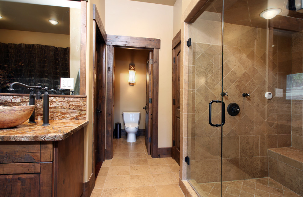 Großes Rustikales Badezimmer En Suite mit profilierten Schrankfronten, dunklen Holzschränken, Unterbauwanne, Eckdusche, beigen Fliesen, beiger Wandfarbe, Aufsatzwaschbecken, beigem Boden und Falttür-Duschabtrennung in Denver