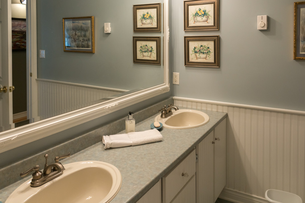 Imagen de cuarto de baño romántico con armarios con rebordes decorativos, puertas de armario blancas, ducha esquinera, sanitario de una pieza, paredes azules y suelo de baldosas de cerámica