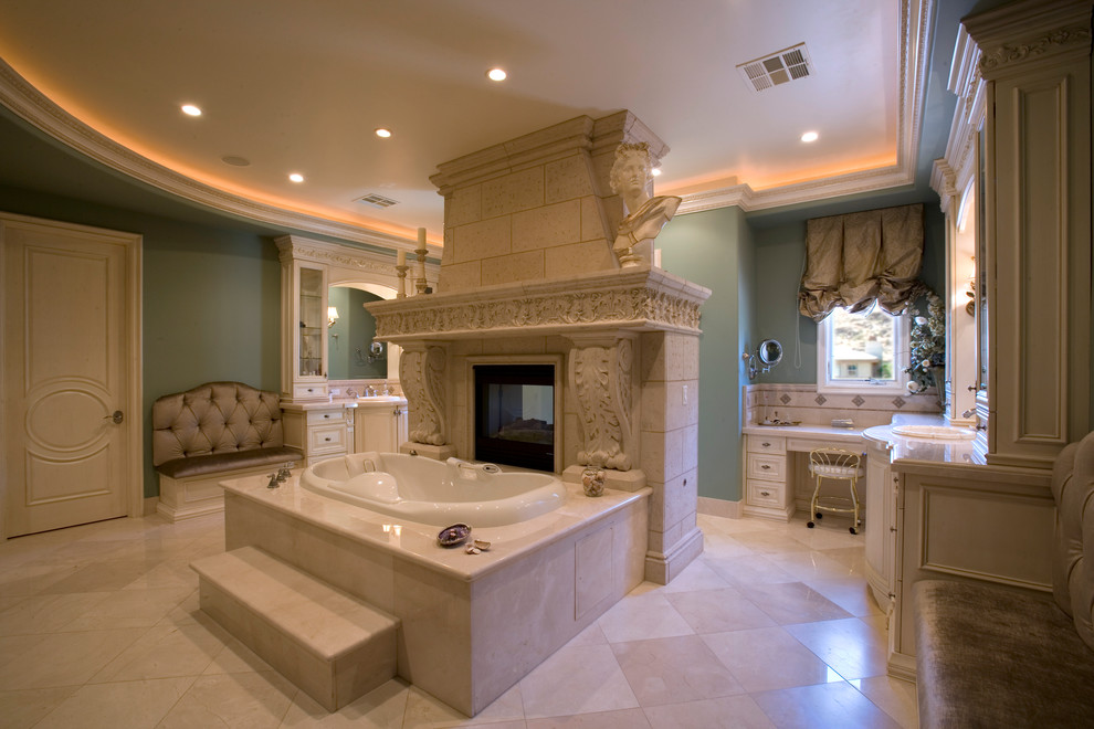 Imagen de cuarto de baño principal clásico grande con puertas de armario blancas, bañera encastrada, paredes azules, lavabo encastrado y suelo beige