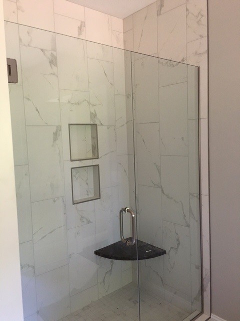 Aménagement d'une douche en alcôve classique de taille moyenne avec un carrelage gris, un carrelage blanc, des carreaux de porcelaine et une cabine de douche à porte battante.