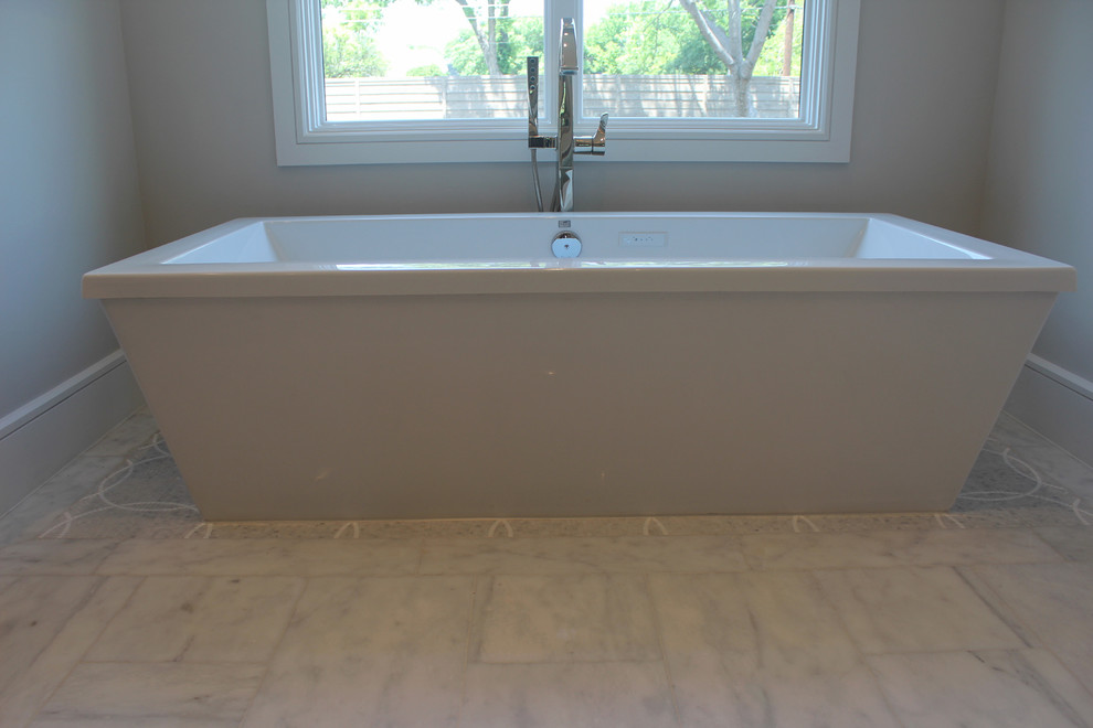 На фото: главная ванная комната среднего размера в стиле неоклассика (современная классика) с отдельно стоящей ванной, мраморным полом и белым полом