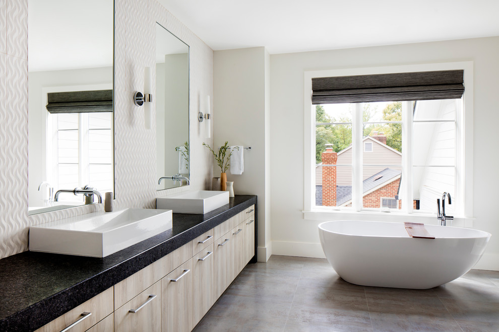 Example of a large transitional master beige tile gray floor freestanding bathtub design in DC Metro with flat-panel cabinets, light wood cabinets, white walls, quartz countertops and a vessel sink