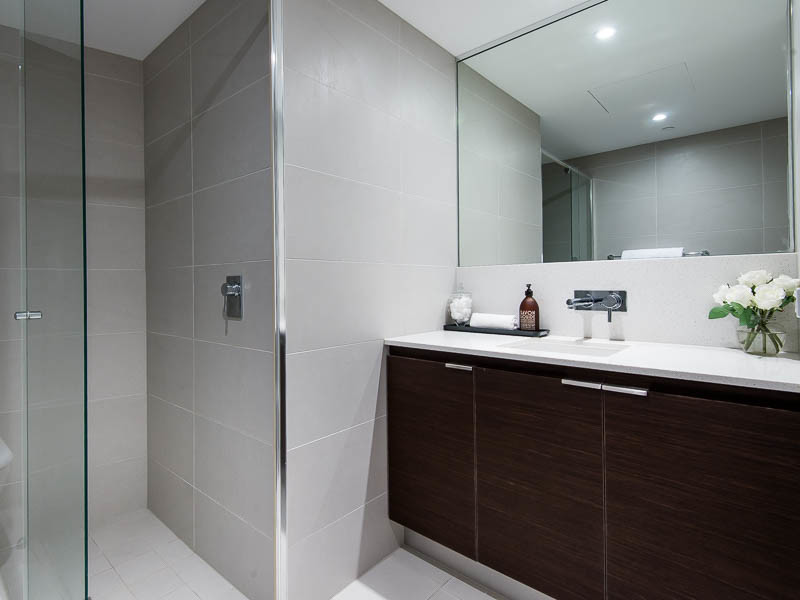 Esempio di una stanza da bagno con doccia moderna di medie dimensioni con ante in legno bruno, top in superficie solida, piastrelle beige, piastrelle in ceramica, pareti bianche e pavimento con piastrelle in ceramica