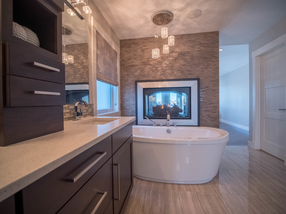 Inspiration for a traditional ensuite bathroom in Calgary with shaker cabinets, a freestanding bath and engineered stone worktops.